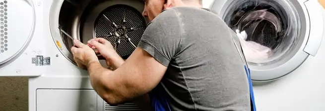 Dryer repair technician fixing a clothes dryer drum in Newark, NJ