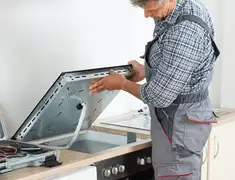 Appliance repair technician installing a built-in cooktop in Newark, NJ