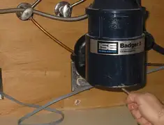 Garbage disposal repair technician tightening the mounting ring under a sink in Newark, NJ