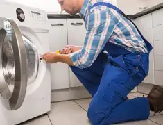 Washing machine repair technician servicing a front-load washer in Newark, NJ
