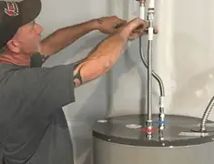 Water heater repair technician tightening supply line connections in Newark, NJ